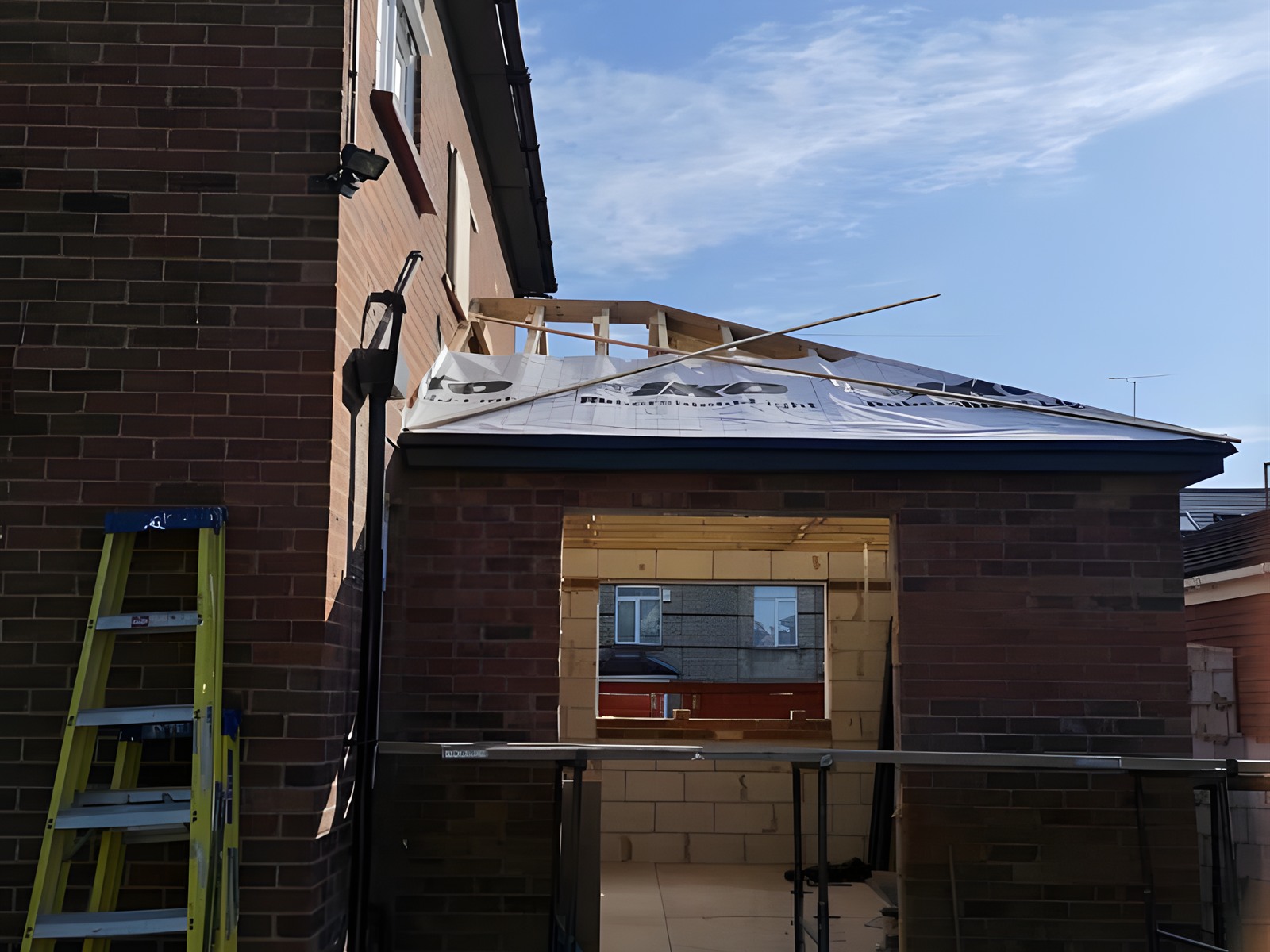 Single storey rear extension under construction with new roof structure and blockwork
